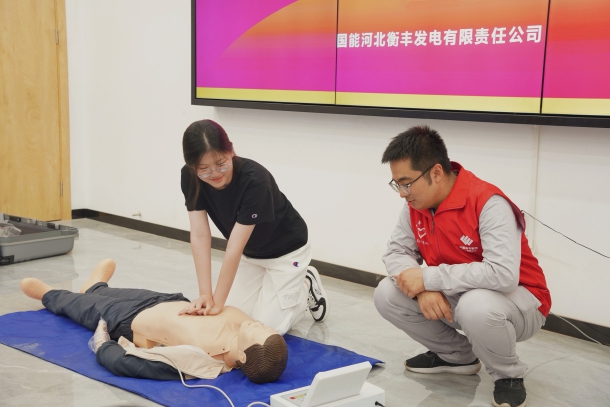 图为志愿者指导居民进行心肺复苏演示