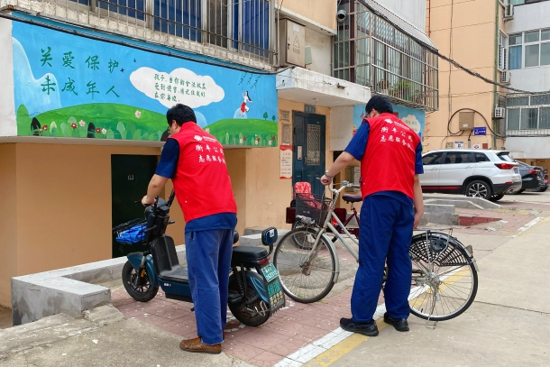 图为志愿者规范摆放小区非机动车