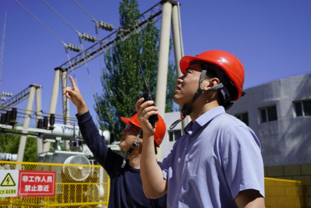 图为刘帅(右)在现场指挥作业