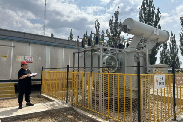 图为吴雪刚在查看变压器运行状况