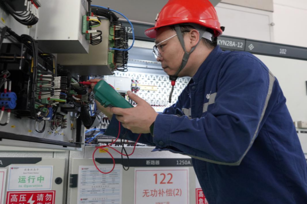 图为张建军在检查排除设备故障