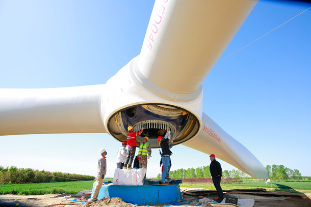 图为风电项目工程技术人员正在安装轮毂和机舱螺栓